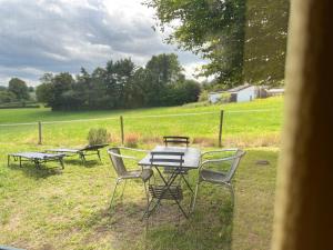 un tavolo da picnic e sedie in un campo di WalHOME: Hohes Venn, 3 Grenzen, Natur 