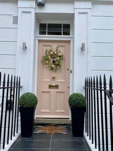 een voordeur van een huis met een krans erop bij Victoria Belgravia Townhouse in Londen