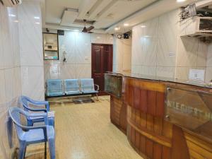 a waiting room with two blue chairs and a bar at Nile Guest House in Chennai