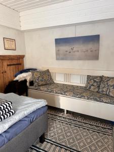 Habitación con 2 camas y sofá en Savikulma savihuone B&B, en Mynämäki