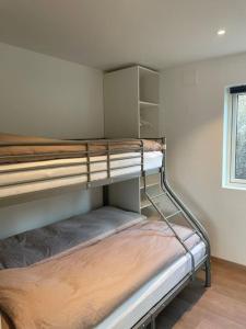 Ce dortoir comprend 2 lits superposés et une fenêtre. dans l'établissement Eksklusiv Rorbu - Havblikk 1 - Båtutleie, à Bekkjarvik