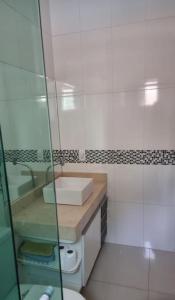a white bathroom with a sink and a mirror at casa entero piscina privada in Aparecida de Goiania