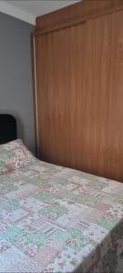 een slaapkamer met een bed met een houten hoofdeinde bij casa entero piscina privada in Aparecida de Goiania