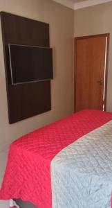 a bedroom with a bed with a red blanket at casa entero piscina privada in Aparecida de Goiania