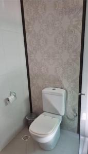 a bathroom with a toilet and a wall at casa entero piscina privada in Aparecida de Goiania