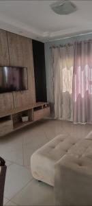 a living room with a couch and a flat screen tv at casa entero piscina privada in Aparecida de Goiania