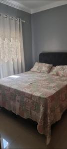a bedroom with a bed with a blanket on it at casa entero piscina privada in Aparecida de Goiania
