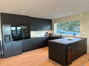 a kitchen with black cabinets and a black counter top at Eksklusiv Rorbu - Havblikk 1 - Båtutleie in Bekkjarvik