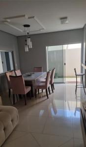 een woonkamer met een eettafel en stoelen bij casa entero piscina privada in Aparecida de Goiania