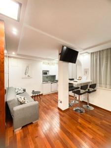 a living room with a couch and a tv on a wall at Main Street Studio and Rooms in Zadar