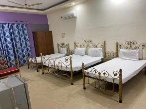 fila de camas en una habitación en Hotel New Star, en Multán