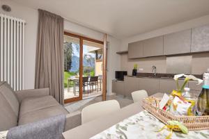a kitchen and living room with a couch and a table at CallaLillyJardin in Malcesine