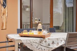 una mesa con un mantel blanco y una bandeja de comida en CallaLillyJardin, en Malcesine