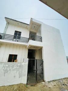 a white building with a gate in front of it at Ashu Homestay in Ayodhya