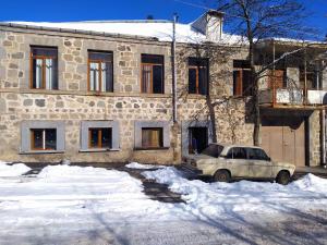 a truck parked in front of a building in the snow at Verishen Guest House B&B in Goris