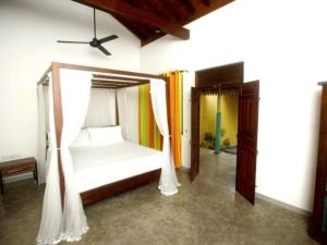 1 dormitorio con 1 cama con mosquitera en Nidahasa Heritage Villa Wadduwa, en Wadduwa