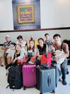 un groupe de personnes assis à côté de leurs bagages dans l'établissement Toro Homestay, à Hội An