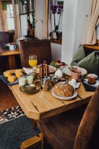 uma mesa de madeira coberta com comida e um copo de vinho em Hotel Forsthof em Sankt Johann im Pongau