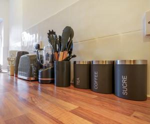 a row of containers with utensils on a wooden floor at Serviced Accommodation Next to Liverpool city Centre/station / stadium in Liverpool