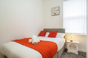 a bedroom with a bed with red and white pillows at Serviced Accommodation Next to Liverpool city Centre/station / stadium in Liverpool
