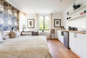 a bedroom with a large bed and a kitchen at Little Lake Haven in Cape Town