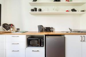 a kitchen with a black microwave and a counter at Little Lake Haven in Cape Town +18 photos