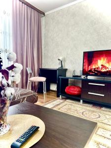 a living room with a television and a fireplace at Двухкомнатная квартира в центре in Semey
