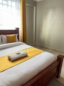 a bed with a towel sitting on top of it at The comfortplace 303 Oak in Kericho