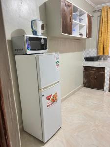 a kitchen with a microwave on top of a refrigerator at The comfortplace 303 Oak in Kericho