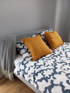 a bed with yellow pillows on it in a room at Apartment Inter Trade fair Poznan in Poznań