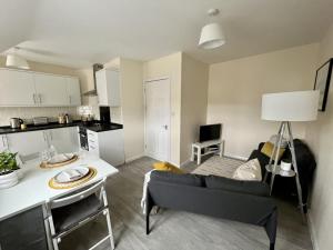 eine Küche und ein Wohnzimmer mit einem Sofa und einem Tisch in der Unterkunft CENTRAL, newly refurb 2 bed flat with FREE PARKING in Cambridge