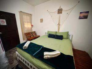 a bedroom with a green bed with towels on it at Walking street hostel & homestay at Haadrin in Haad Rin