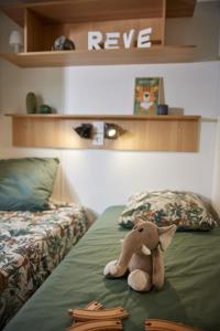 un animal de peluche sentado encima de una cama en Residence Marea Resort, en Santa-Lucia-di-Moriani