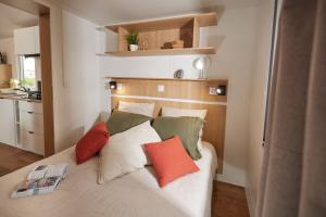 um quarto com uma cama com almofadas em Residence Marea Resort em Santa-Lucia-di-Moriani