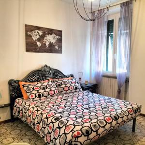 una camera da letto con un grande letto e un piumone colorato di Casa dei MoMi a Piombino