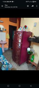 um frigorífico roxo num quarto com uma mesa em Aleya Home Stay em Calcutá