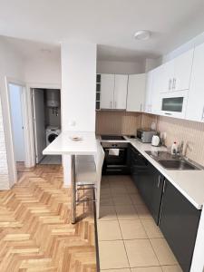 cocina con armarios blancos y suelo de madera en Apartment 4th. Floor, en Banja Luka