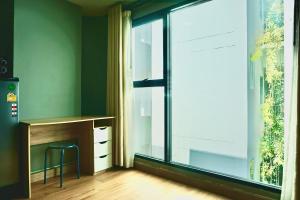 a room with a desk and a large window at Hip and funky apartment silom Soi 3, with rooftop view in Bangkok
