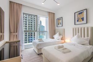 a hotel room with two beds and a large window at Luxe Living in Beachfront / 2BR in Dubai Marina in Dubai