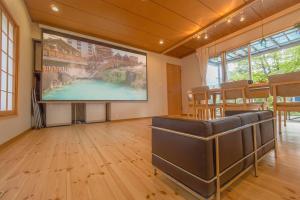 a large screen in a room with a table and chairs at Private hot-spring Villa in Kusatsu in Kusatsu