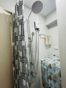 uma casa de banho com chuveiro e cortina de chuveiro em A relaxing and accessible condominium unit. em Manila
