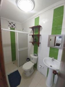 a bathroom with a white toilet and a sink at Hotel Sierra Nevada B&B SAS in Valledupar