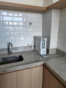 a kitchen counter with a sink and a coffee maker at A uma quadra da praia de Copacabana in Rio de Janeiro