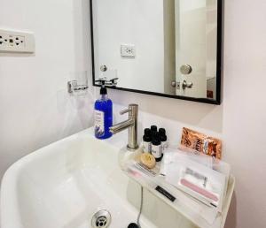 a bathroom sink with a blue bottle of soap and a mirror at WV2 Condotel Luxury in Iloilo City