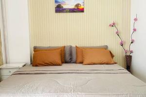 a bed with orange pillows in a bedroom at WV2 Condotel Luxury in Iloilo City