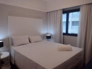 a bedroom with a large white bed with a window at Conforto e Comodidade no Itaim Bibi-Apto 804 in Sao Paulo