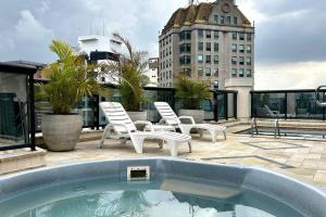a patio with two chairs and a swimming pool at Conforto e Comodidade no Itaim Bibi-Apto 804 in Sao Paulo