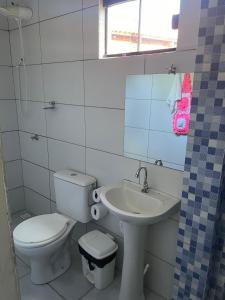 a white bathroom with a toilet and a sink at Pousada Ambiente Familiar in Ponte Alta do Tocantins