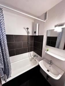 een badkamer met een wastafel, een bad en een toilet bij Moderne Ferienwohnungen in Kleve in Kleve