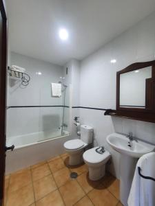 a bathroom with a toilet and a sink and a shower at POSADA LOS PEDREGALES in El Granado